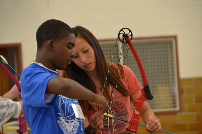 Lakota student teaching archery.