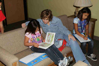 Kelly and Erin work on their homework with their houseparent.