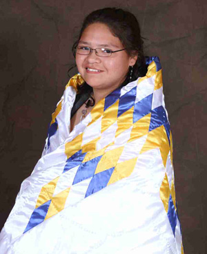 Native American student wrapped in her star quilt