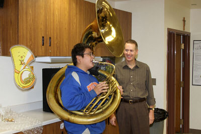 Thomas holds a tuba that an artist brought to St. Joseph's.